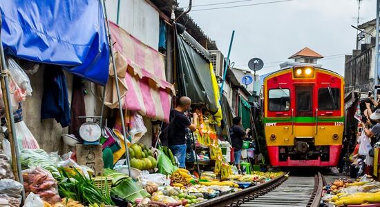 Iconic train tracks through Mae Klong Market for a Mae Klong Tours banner with Legend Travel Group.